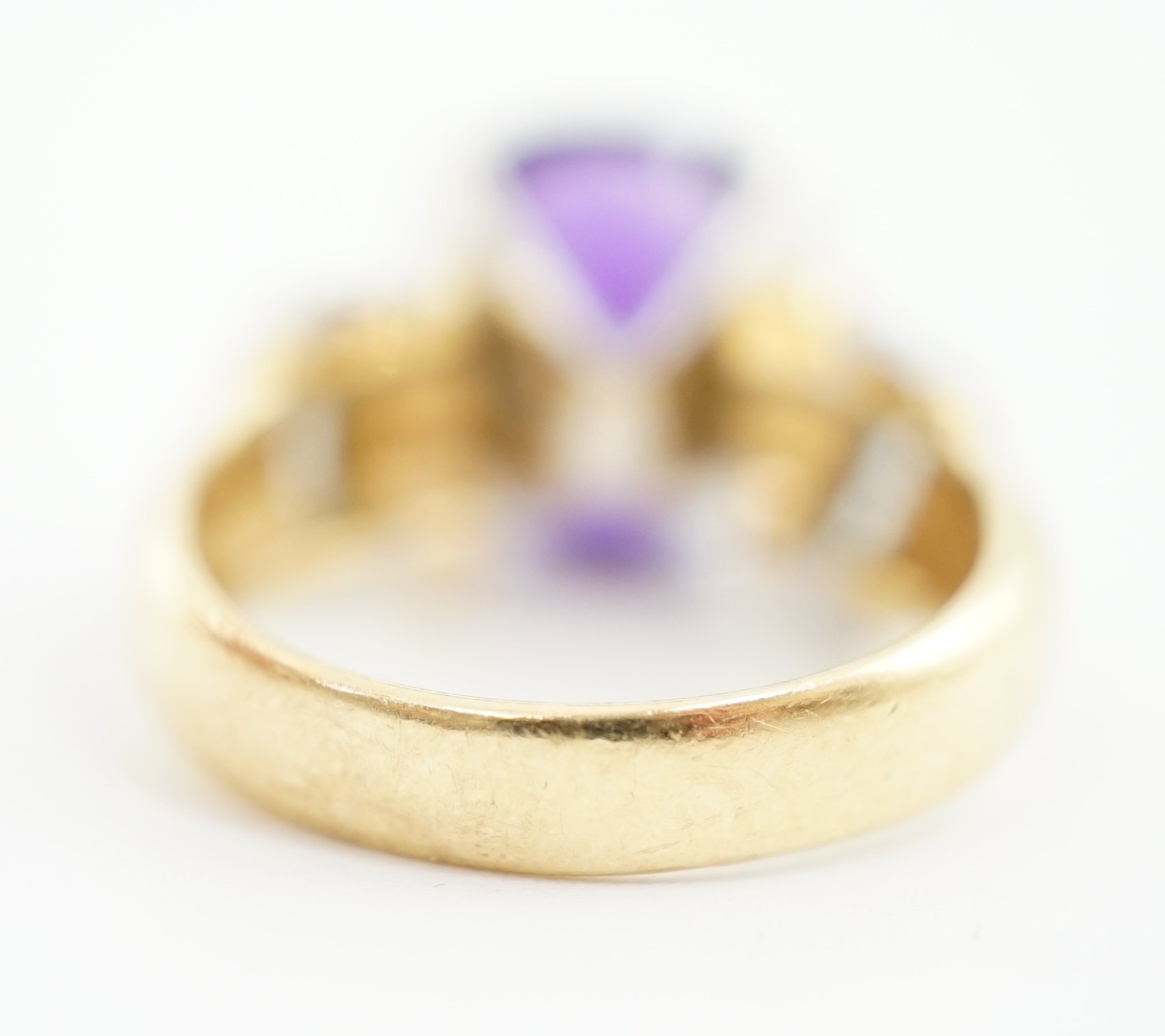 A modern 18ct gold and single stone cushion cut amethyst set dress ring, with ten stone round brilliant cut diamond set shoulders